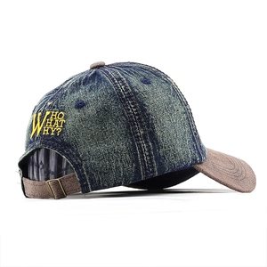 Detail of vintage denim baseball cap with yellow embroidery and adjustable brass buckle