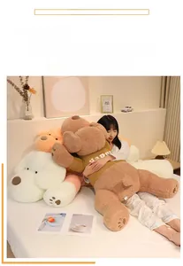 Large plush dog pillow in warm bedroom setting wearing yellow 'Happy' sweater