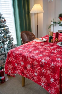 Close-up of red Christmas tablecloth with white snowflake prints in a festive dining room