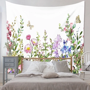 Detail of floral watercolor wall tapestry showing pink daisies and wildflowers in bedroom