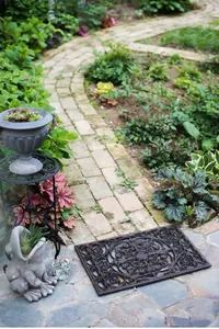 Zerbino vintage in ghisa con motivi a volute ornati in un ambiente da giardino