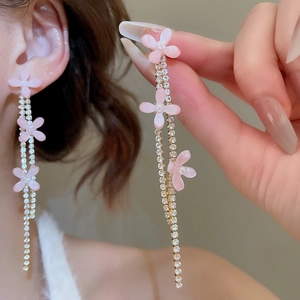 Detail of pink resin flower earrings with sparkling gold tassel and zircon stones