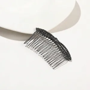 Close-up of black metal hair comb with sparkling rhinestones for elegant hair styling