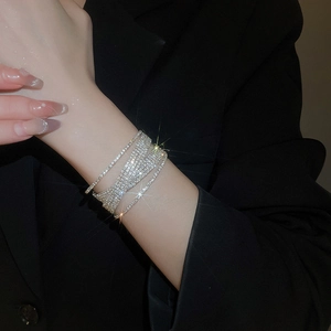 Detailed view of shimmering layered pearl bracelet with crystals on a black suit cuff