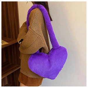Detail of a purple heart-shaped plush shoulder bag featuring soft fox fur texture on a model