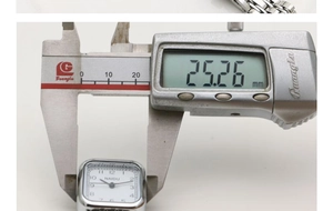 Macro shot measuring the 25mm width of a square silver quartz watch with a digital caliper