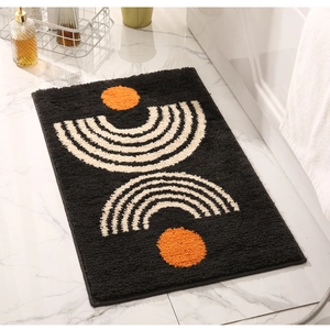 Detailed view of black tufted bathroom mat with orange and beige geometric patterns