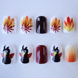 Short square press-on nails with Thanksgiving maple leaf and turkey designs in warm tones