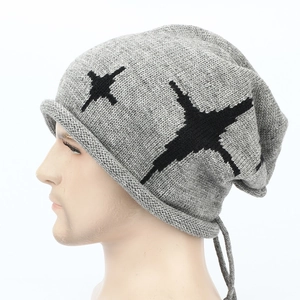 Detail showing grey knitted beanie texture with black star pattern and rolled edge
