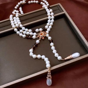 Detail of vintage flower pendant necklace with pearls and orange resin stones