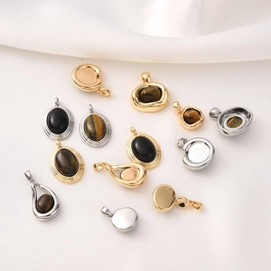 Detail of 18K gold and silver tiger eye stone pendants on white silk background