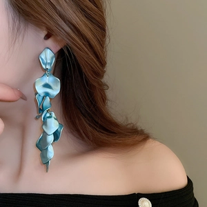 Detailed view of long blue tiered petal tassel earrings worn by a model in soft lighting