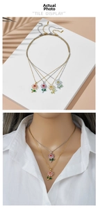 Macro detail of floral pendant necklace featuring colorful crystals on polished gold and silver chain