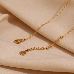 Close-up of golden stainless steel lobster clasp and adjustable extension chain detail