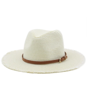 Detailed close-up of straw sun hat featuring frayed edges and brown leather decorative band