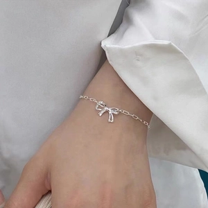 Elegant S925 silver bow hollow chain bracelet for women on a model's wrist