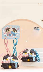 Macro shot of hugging penguins magnetic keychains with heart and triangle patterns