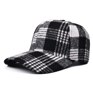 Close-up of black and white tartan wool fabric texture on a structured baseball cap