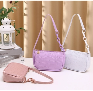 Detail of crocodile pattern hobo bags in purple, white, and pink faux leather material