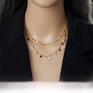 Detail of double-layer gold chain necklace featuring star pendant and colorful beads