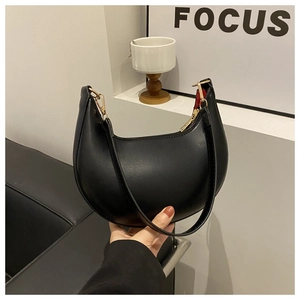 Close-up of black crescent shoulder bag with smooth leather finish and gold zipper detail