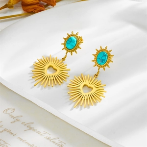 Vintage gold heart earrings with blue turquoise and sunburst texture on white surface