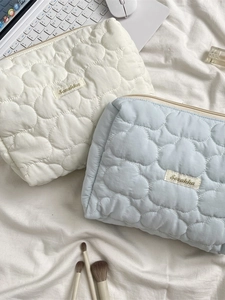 Quilted cloud cosmetic bag in cream and blue colors for makeup storage and organization