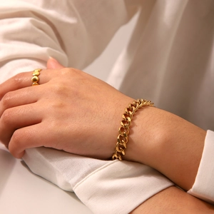 Golden OT buckle Cuban bracelet and shell ring set on minimalist white background