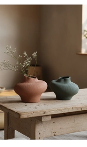 Primer plano de jarrones de cerámica minimalistas en terracota y verde oscuro
