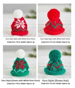 Close-up of mini knitted Christmas hats with snowflake patterns and fluffy pom-poms