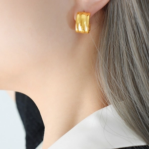 Minimalist gold plated titanium steel C-shaped hoop earrings worn by a model