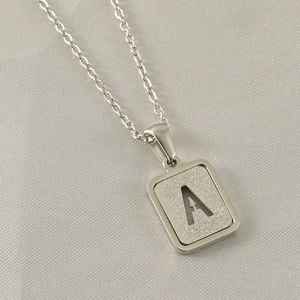 Detailed close-up of a silver stainless steel necklace with a hollow letter A pendant