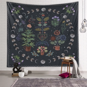 Detail of bohemian black moon phase tapestry with floral elements on a white brick wall