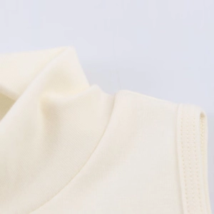 Close-up of the high neckline and stitching details on a beige knitted sleeveless vest