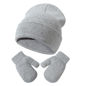 Close-up of grey ribbed knit baby hat and matching mittens with soft fabric texture