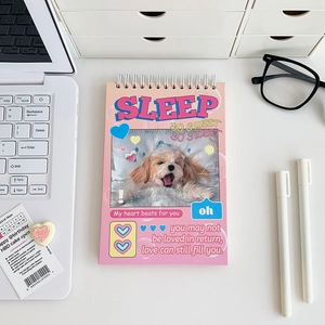 Flat lay of pink animal spiral notebook with cute sleeping dog and laptop on desk