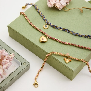 Détail de bracelets en acier inoxydable 18k avec cordons colorés et pendentifs yeux