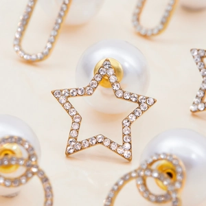 Macro detail of star-shaped rhinestone earring with a large white pearl backing