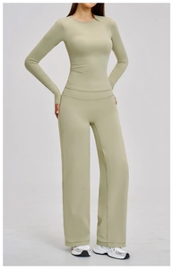 Detail of light olive yoga set featuring long sleeve top with thumbholes and wide leg pants
