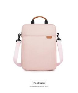 Detailed view of pink Oxford fabric laptop bag with brown leather handles and strap