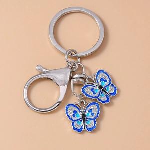 Detailed macro view of silver alloy keychains featuring blue enamel butterfly pendants