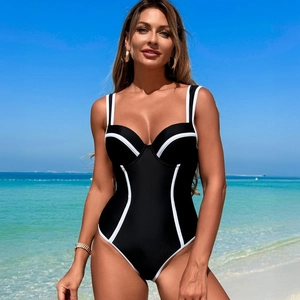 Detail of high-waist one-piece swimsuit with black and white contrast piping on beach