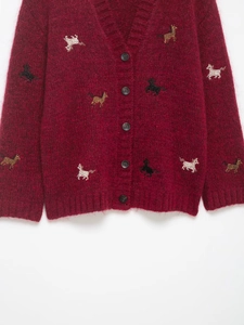 Detail of dark red knit cardigan with colorful pony embroidery and soft mohair texture