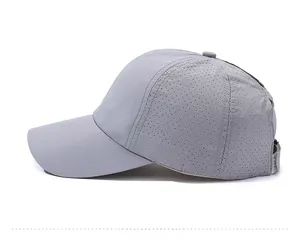 Close-up of the breathable side mesh and curved brim on the light grey sports baseball cap