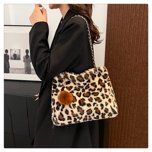 Close-up of leopard print plush bag with gold chain strap and fluffy ball charm