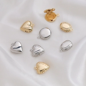 Detailed macro view of various 14k gold-filled and silver heart-shaped locket pendants
