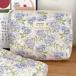Quilted floral makeup bag with blue flowers and large capacity on wooden desk