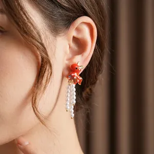 Vintage enamel red horse earrings with elegant white pearl tassels on model