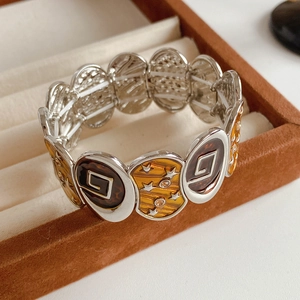 Vue macro détaillée du bracelet vintage en émail avec étoiles et motif écaille dans son coffret