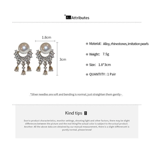 Detailed macro view of silver tassel earrings with pearls and rhinestones size 1.8 by 3cm